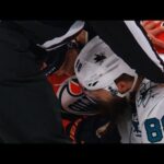 Patrick Maroon tugs on the beard of Brent Burns